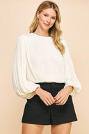 White pleated blouse in white with long balloon sleeves.
