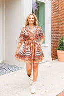 Woman in a patterned dress standing outside a building