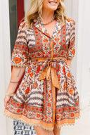 Woman wearing a patterned dress with orange and beige accents.
