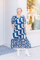 Woman wearing a blue and white abstract patterned maxi dress.