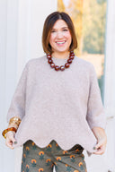 Taupe scalloped edge sweater.