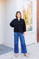 Black jersey knit top and pintuck jeans.