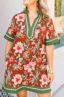 Woman wearing a floral dress with green accents outdoors.