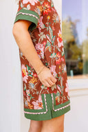 Person wearing a floral dress with green accents in an outdoor setting