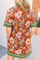 Woman wearing a floral dress with a brown background