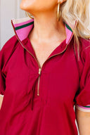 Crimson dress with a zipper and pink collar worn by a person