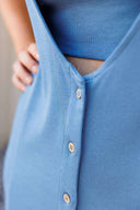 Close-up of a blue buttoned front dress with a neutral background