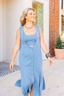 Woman wearing a blue dress with cut-out design outdoors.