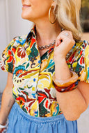 Person wearing a colorful patterned shirt and blue denim bubble skirt with a blurred background