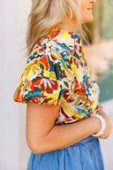 Person wearing a colorful patterned shirt and blue denim bubble skirt with a blurred background