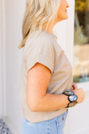 Person wearing a beige top and blue jeans with a blurred background