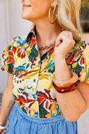 Person wearing a colorful patterned shirt and blue denim bubble skirt with a blurred background