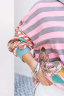 Person wearing a pink and gray striped shirt with a boho floral design.