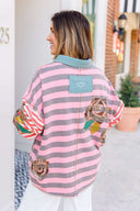 Person wearing a pink and gray striped shirt with a boho floral design.