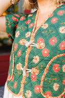 Green floral patterned top with a close-up of the neckline.