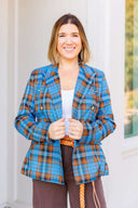 Woman wearing a blue plaid blazer outside Laundry Dae Boutique.