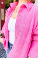 Person wearing a bright pink corduroy jacket with a blurred background