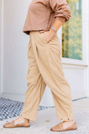 Woman in a brown sweatshirt and beige corduroy pants standing outside Laundry Dae Boutique. 