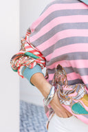 Person wearing a pink and gray striped shirt with a boho floral design.