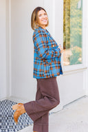 Woman in blue plaid blazer and brown jeans standing outside Laundry Dae Boutique.