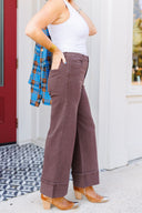 Woman in white tank top and brown jeans standing outside Laundry Dae Boutique.