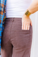 Woman in white tank top and brown jeans standing outside Laundry Dae Boutique.