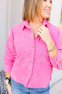 Woman wearing a bright pink button-up shirt, standing against a neutral background.