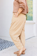 Woman in a brown sweatshirt and beige corduroy pants standing outside Laundry Dae Boutique. 