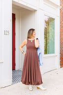 Woman in a brown dress standing outside Laundry Dae boutique.