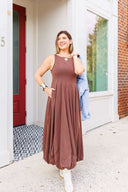 Woman in a brown dress standing outside Laundry Dae boutique.