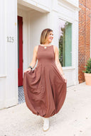 Woman in a brown dress standing outside Laundry Dae boutique.