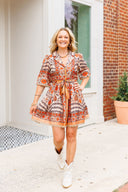 Woman in a patterned dress standing outside a building