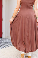 Person wearing a brown dress with a blurred background