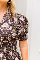 Woman wearing a floral dress with a plain background