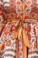 Close-up of a patterned dress with orange and beige accents