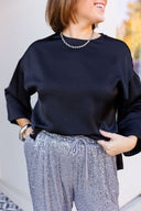 Black satin top and silver sequin jogger pants.