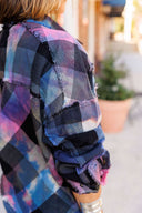 Plaid shirt with colorful patterns worn by a person outdoors