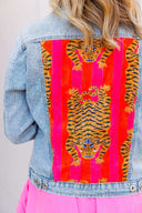 Denim jacket with tiger design on a pink background