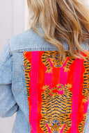 Denim jacket with a vibrant tiger pattern on a red background