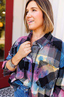 Woman wearing a colorful plaid shirt with a blurred background