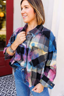 Woman wearing a colorful plaid shirt with a blurred background