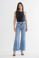 Woman wearing blue jeans and a black top on a white background