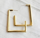 Gold hoop earrings on a marble surface
