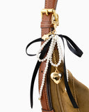 Bag charm featuring pearl and black ribbon with heart pendant.